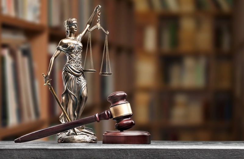 brown gavel with a Ledy justice on table