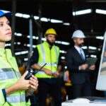 Mechanical engineer woman holding radio working industry wearing safety reflective vest