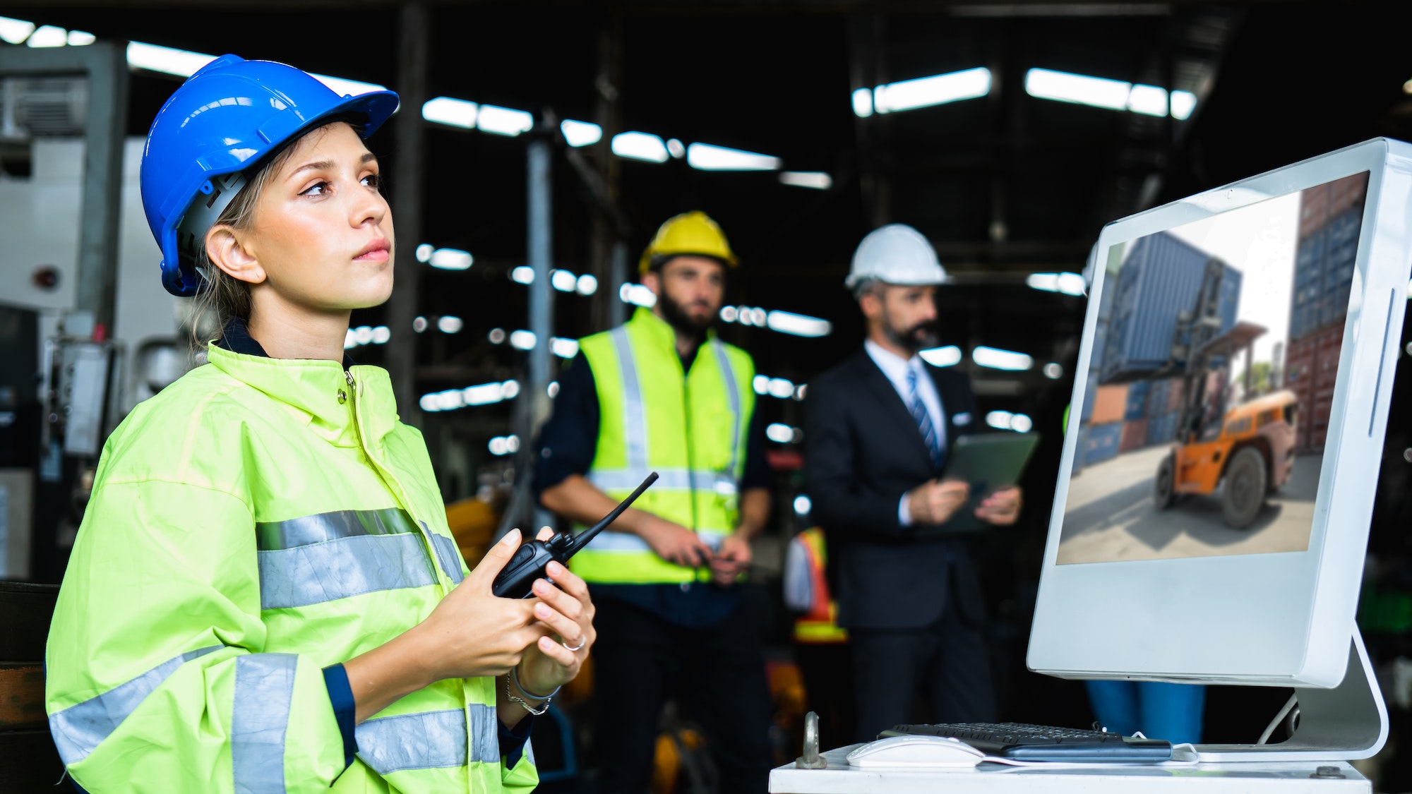 Mechanical engineer woman holding radio working industry wearing safety reflective vest